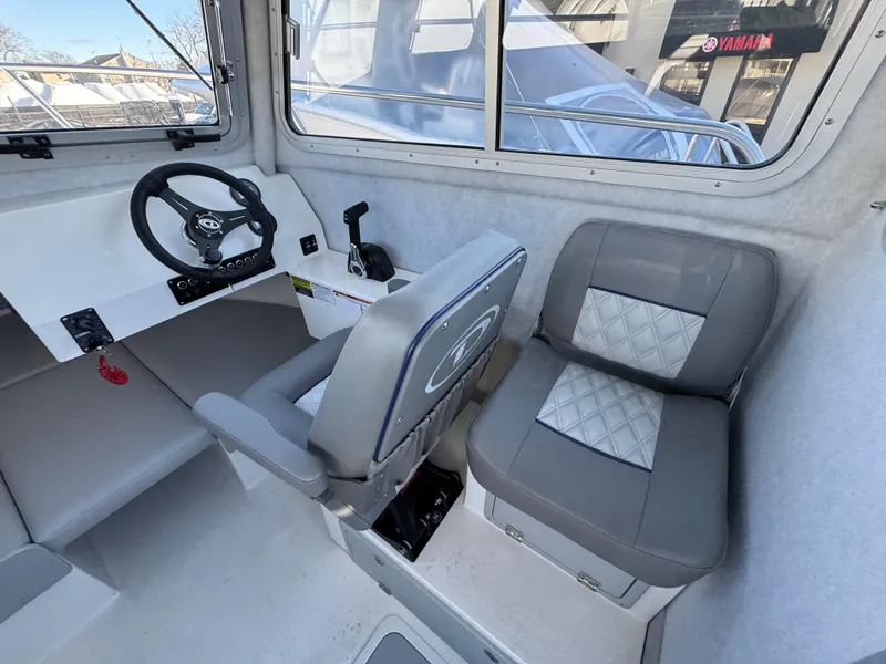 Slide: The Image of Interior of 2025 Defiance Admiral 220 EX boat with steering wheel and seating. - 4