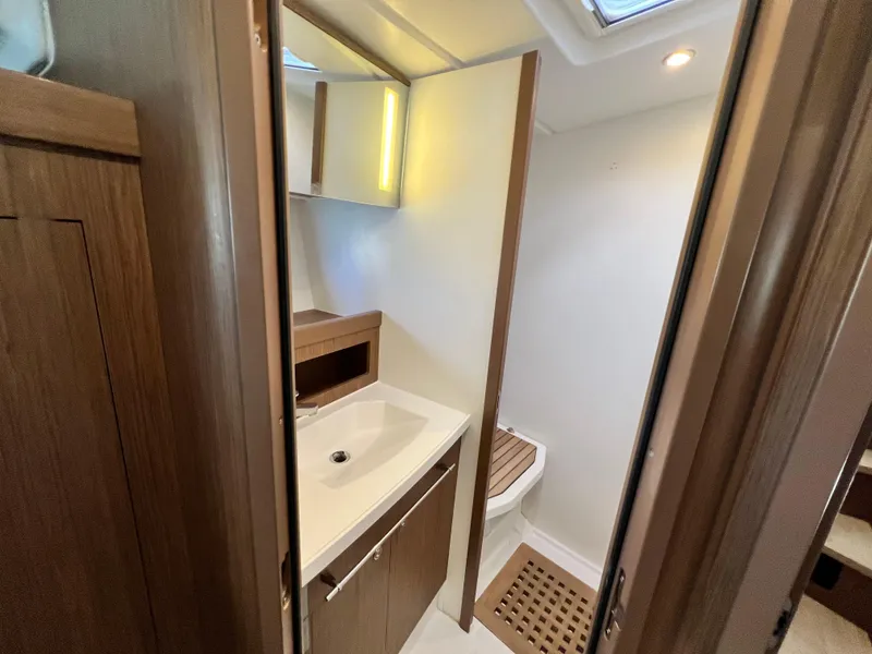 Slide: The Image of 2019 Beneteau Swift Trawler 44 bathroom with modern sink and wooden accents. - 18