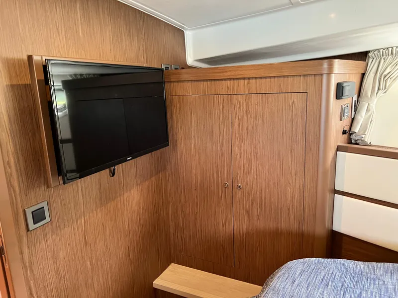 Slide: The Image of Interior of 2019 Beneteau Swift Trawler 44 with TV and wooden cabinetry. - 21