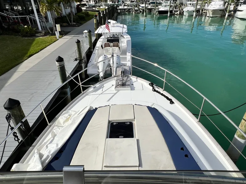 Slide: The Image of 2019 Beneteau Swift Trawler 44 docked in a marina, clear turquoise water. - 24
