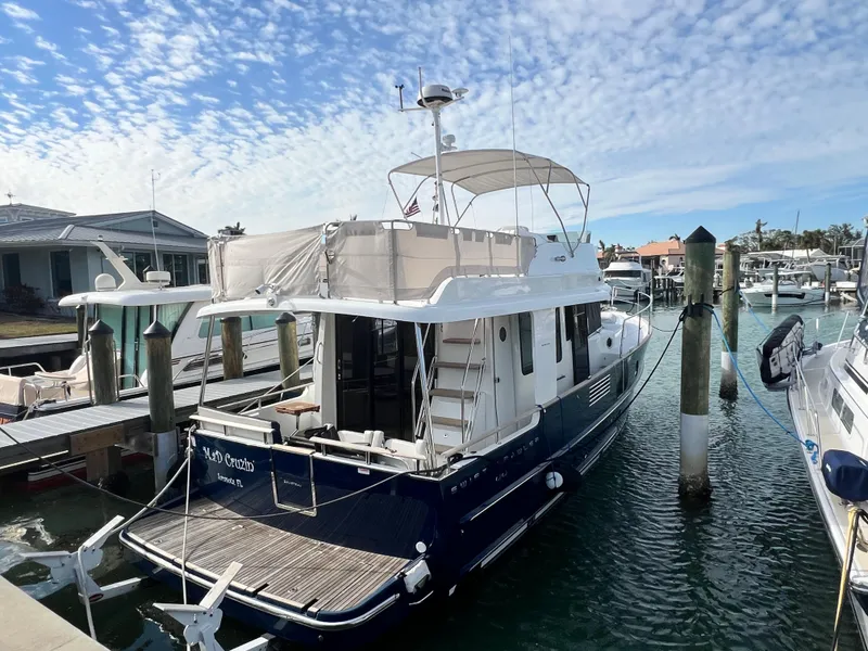 Slide: The Image of 2019 Beneteau Swift Trawler 44 docked at marina under blue sky. - 3