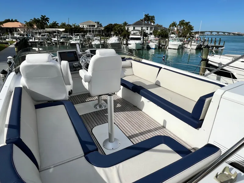 Slide: The Image of 2019 Beneteau Swift Trawler 44 interior with white seating, docked in a marina. - 7