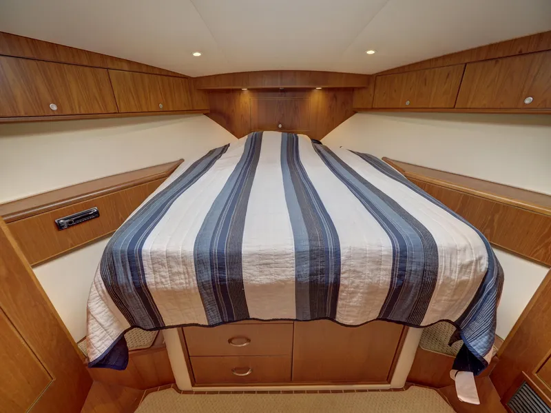 Slide: The Image of Luxurious 2013 Cabo HTX cabin interior with striped bedding and wooden cabinetry. - 13