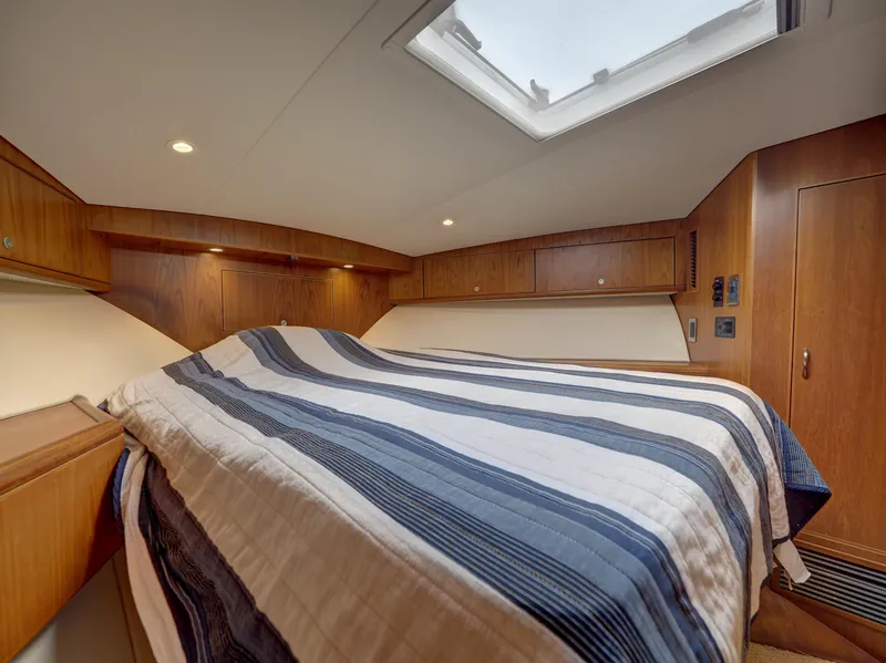 Slide: The Image of Luxurious 2013 Cabo HTX cabin interior with skylight and striped bedding. - 14