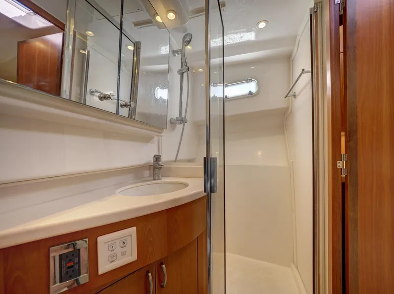 Slide: The Image of Luxurious 2013 Cabo HTX yacht bathroom with glass shower and wooden cabinetry. - 16
