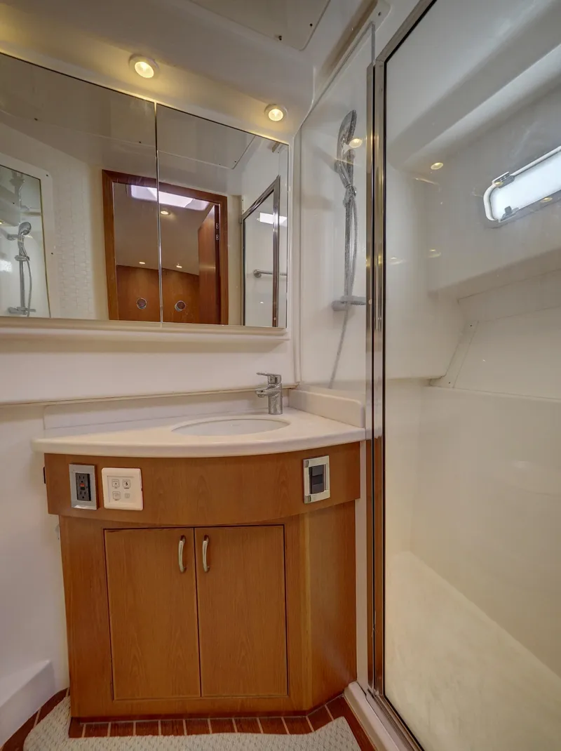 Slide: The Image of Luxurious 2013 Cabo HTX yacht bathroom with modern shower and wooden cabinetry. - 17