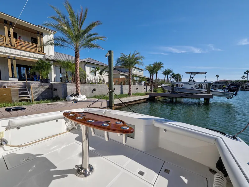 Slide: The Image of 2013 Cabo HTX boat docked by waterfront homes with palm trees. - 19