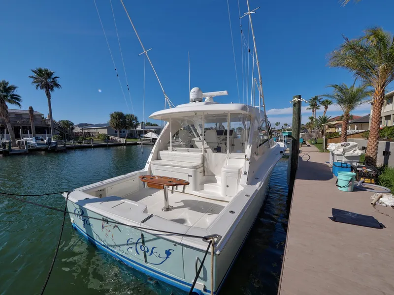 Slide: The Image of 2013 Cabo HTX boat docked in sunny marina with palm trees. - 20