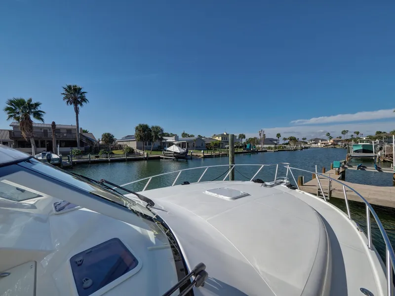 Slide: The Image of 2013 Cabo HTX yacht docked in a scenic marina with palm trees. - 22