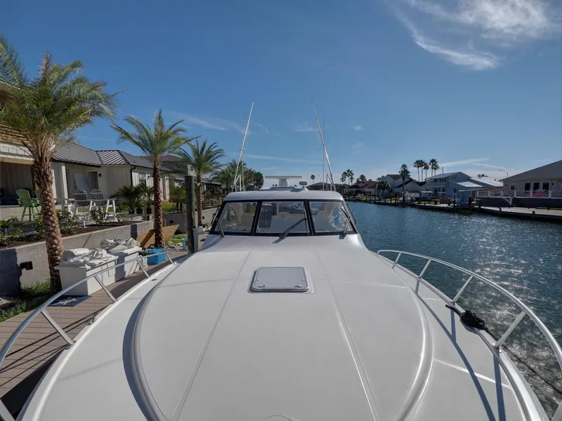 Slide: The Image of Cabo HTX 2013 boat docked by waterfront homes under clear blue sky. - 23