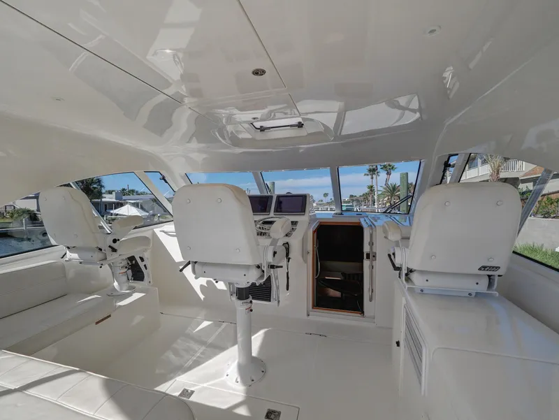 Slide: The Image of Interior of 2013 Cabo HTX boat with white seating and navigation equipment. - 5