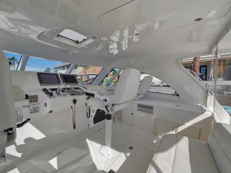Slide: The Image of Interior of 2013 Cabo HTX boat with modern navigation equipment and white seating. - 6