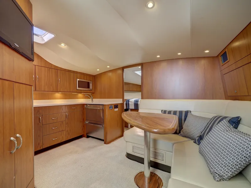 Slide: The Image of Luxurious 2013 Cabo HTX yacht interior with wood cabinetry and cozy seating area. - 8