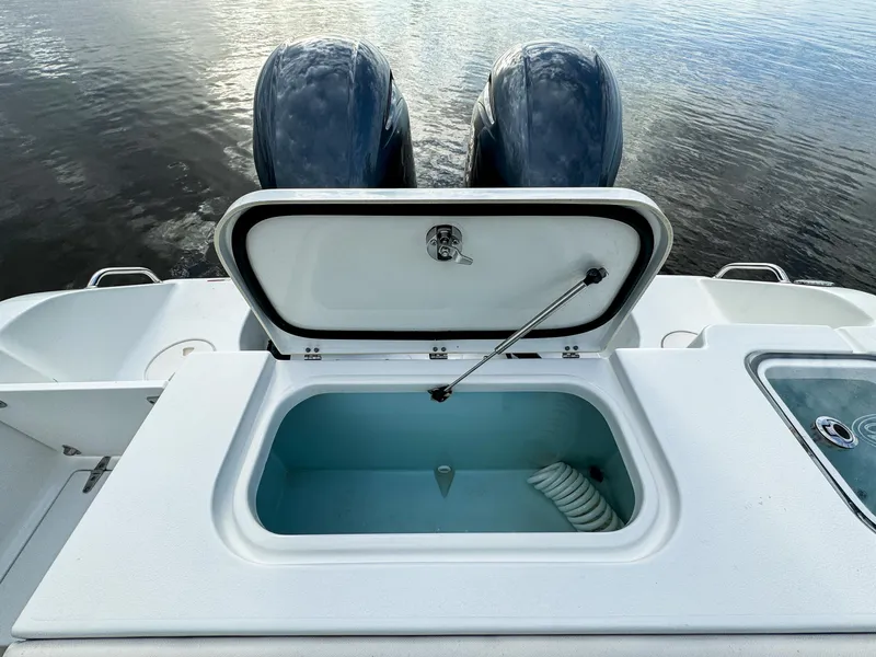 Slide: The Image of 2021 Sea Hunt Gamefish 25 boat with open storage compartment and twin engines. - 21