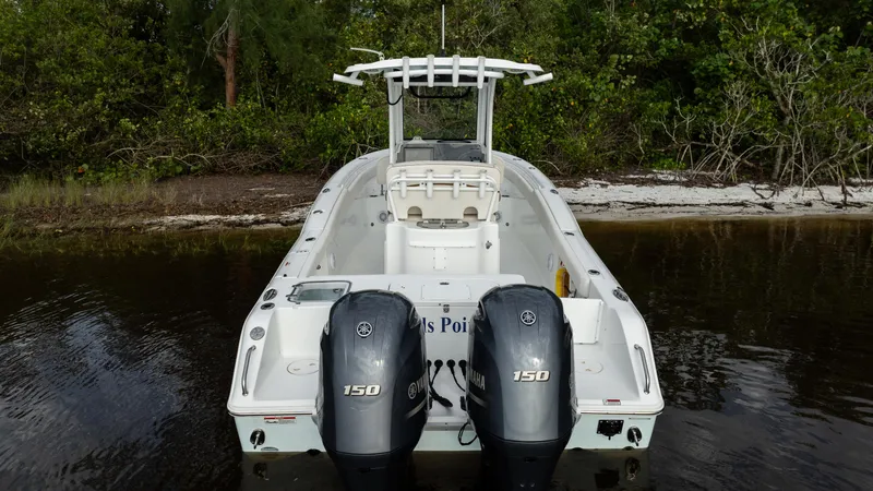 Slide: The Image of 2021 Sea Hunt Gamefish 25 boat with dual Yamaha 150 engines in a serene water setting. - 29