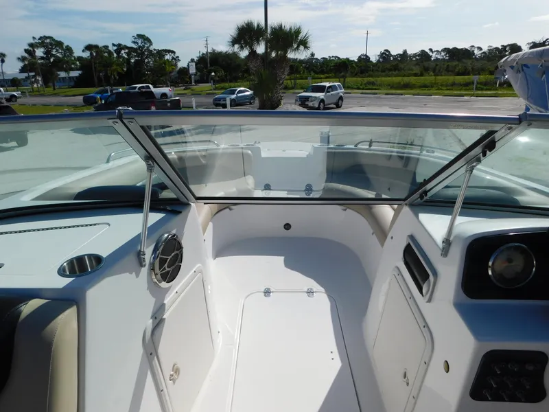 Slide: The Image of 2015 Hurricane SunDeck 187 OB boat interior with open windshield, parked outdoors. - 16