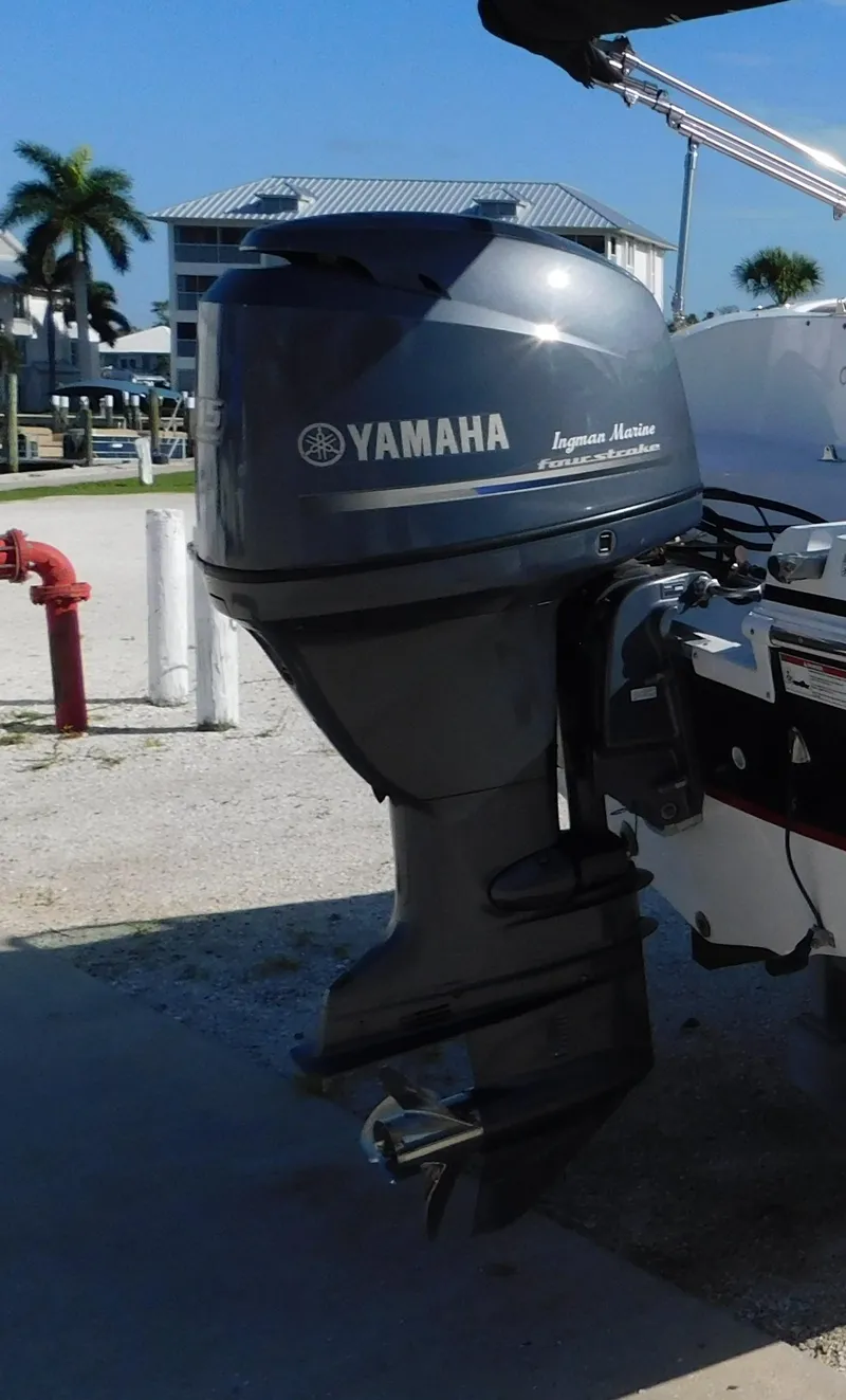 Slide: The Image of Yamaha outboard motor on 2015 Hurricane SunDeck 187 OB boat, parked near palm trees. - 20