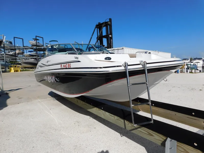 Slide: The Image of 2015 Hurricane SunDeck 187 OB boat on trailer at marina under clear blue sky. - 4