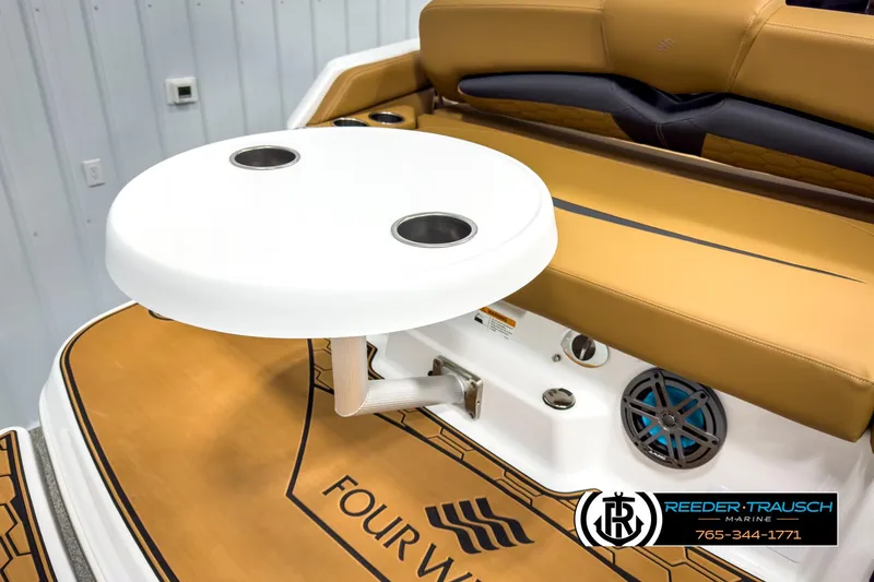 Slide: The Image of 2025 Four Winns HD3 boat interior with tan seating and white table, featuring cup holders. - 49