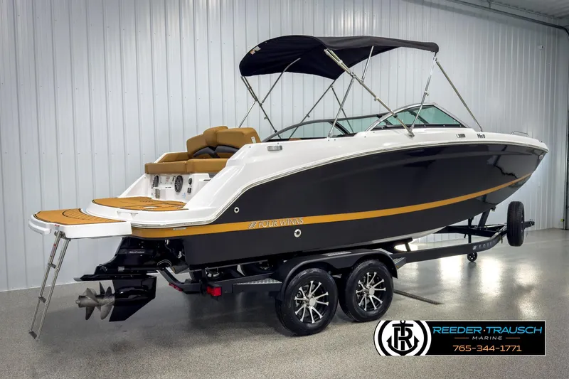 Slide: The Image of 2025 Four Winns HD3 boat on trailer in showroom, featuring sleek design and black hull. - 6