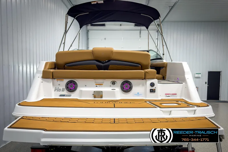 Slide: The Image of 2025 Four Winns HD3 boat interior with tan seating and modern features in a showroom. - 7