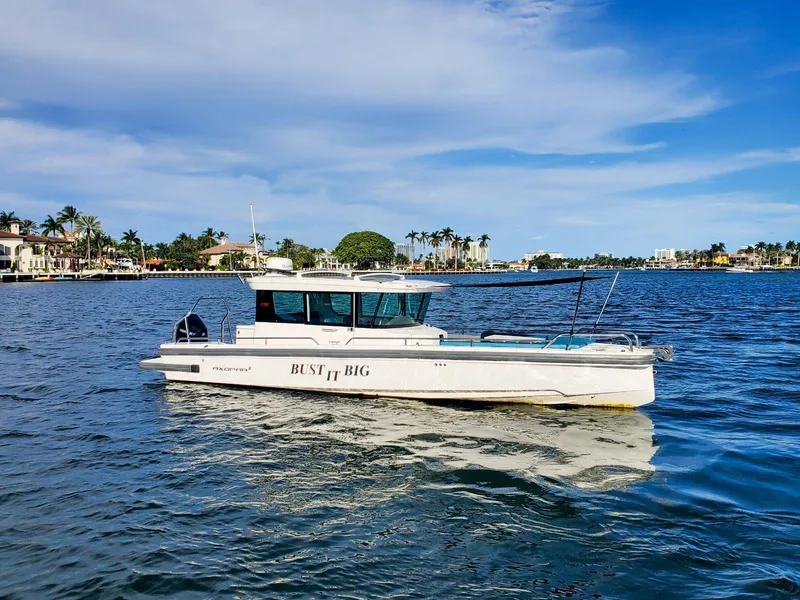 Slide: The Image of 2021 Axopar 28 CABIN boat on a sunny waterfront. - 0