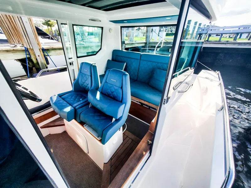 Slide: The Image of 2021 Axopar 28 CABIN interior with blue seating and modern design. - 10