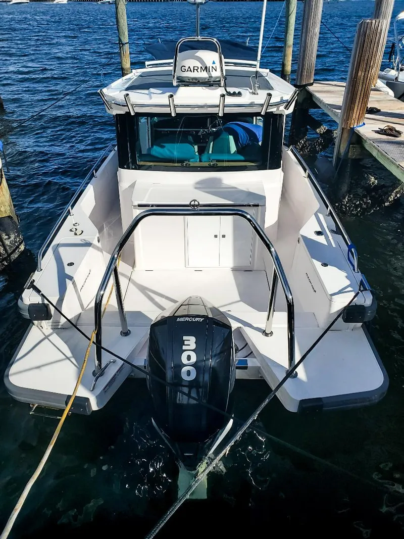 Slide: The Image of 2021 Axopar 28 CABIN boat docked with 300 horsepower engine. - 26