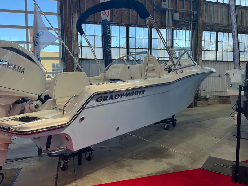 Slide: The Image of 2025 Grady-White Freedom 215 boat displayed indoors with Yamaha engine. - 2
