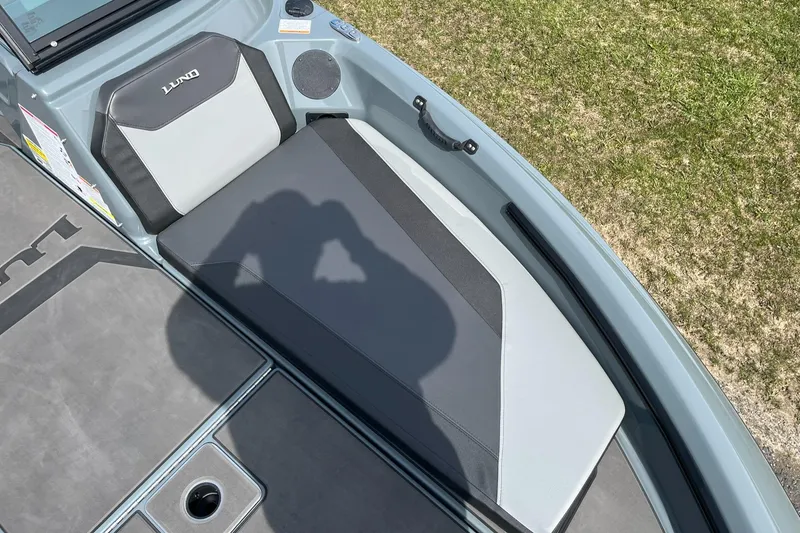 Slide: The Image of 2025 Lund 185 Impact GL boat interior with cushioned seating and speaker. - 17