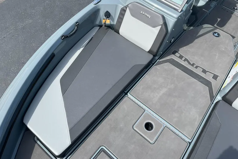 Slide: The Image of 2025 Lund 185 Impact GL boat interior with gray seating and storage compartments. - 18