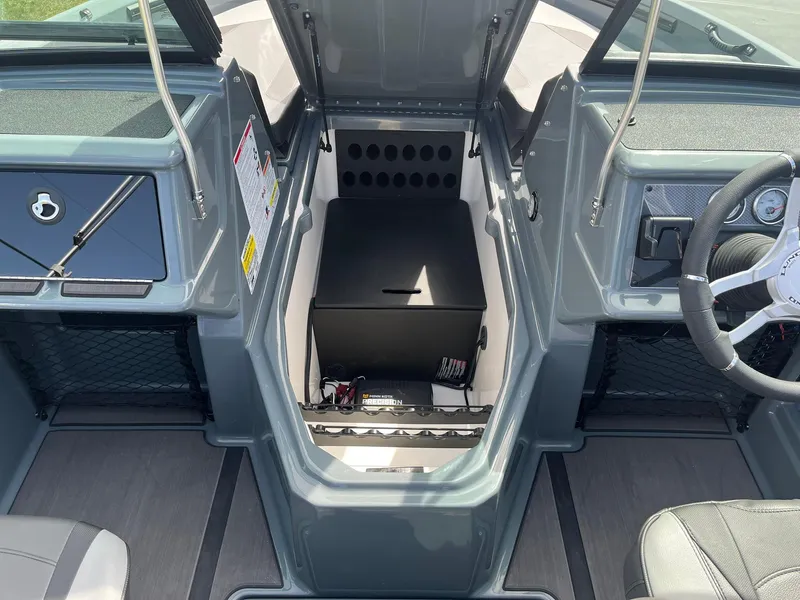 Slide: The Image of 2025 Lund 185 Impact GL boat interior with open storage compartment and steering wheel. - 23