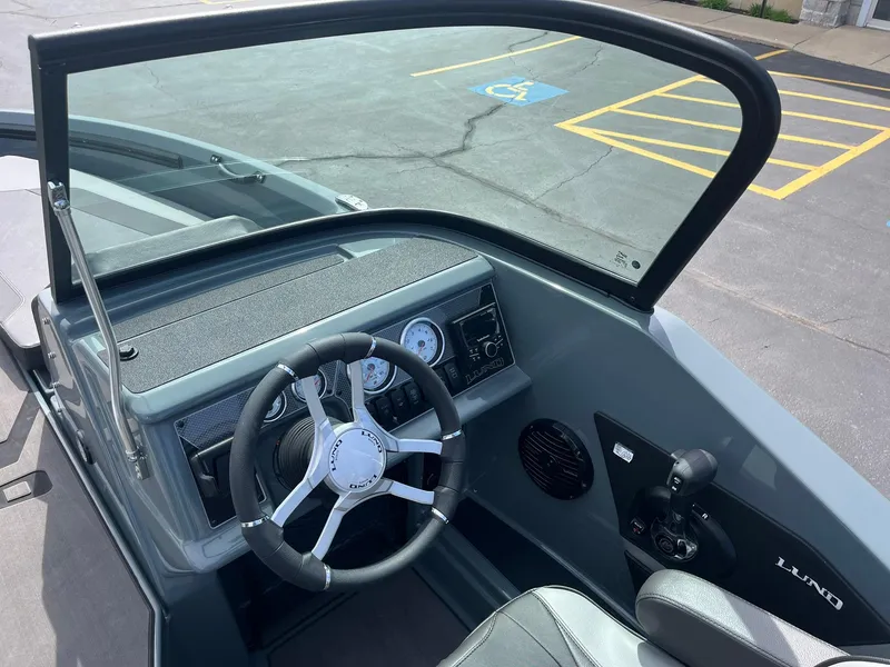 Slide: The Image of 2025 Lund 185 Impact GL boat dashboard with steering wheel and gauges. - 25