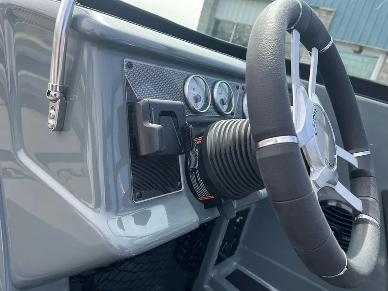 Slide: The Image of 2025 Lund 185 Impact GL boat dashboard with steering wheel and gauges. - 28
