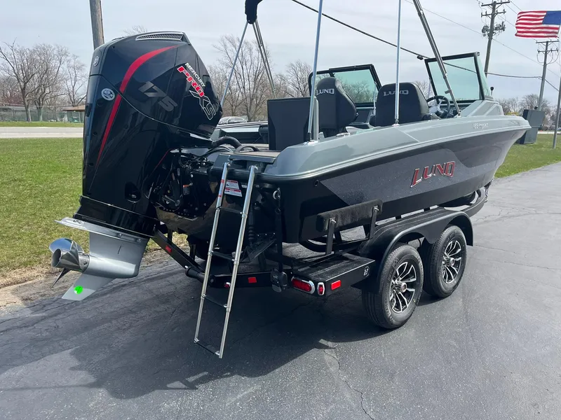 Slide: The Image of 2025 Lund 185 Impact GL boat on trailer, featuring powerful outboard motor and sleek design. - 3