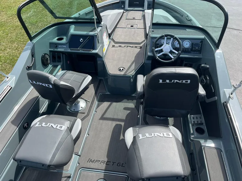 Slide: The Image of 2025 Lund 185 Impact GL boat interior with steering wheel and branded seats. - 7