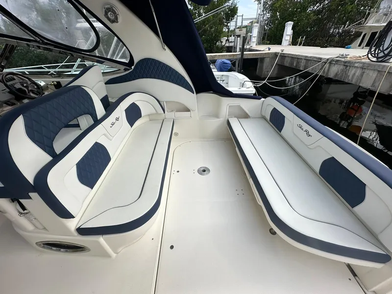 Slide: The Image of Interior seating of 2004 Sea Ray 360 Sundancer boat, featuring blue and white upholstery. - 14