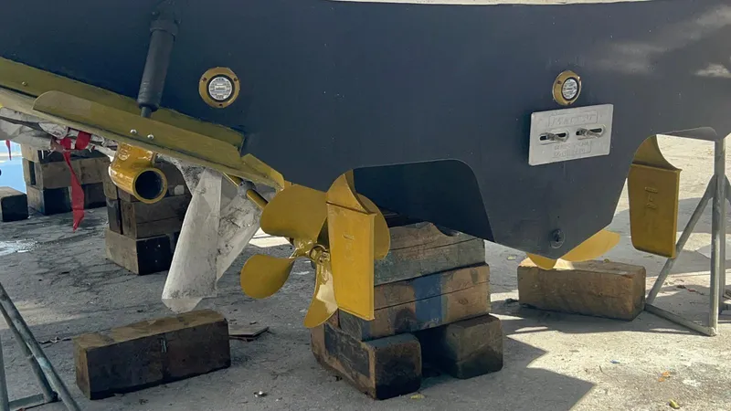 Slide: The Image of 2004 Sea Ray 360 Sundancer propellers and hull on blocks for maintenance. - 15