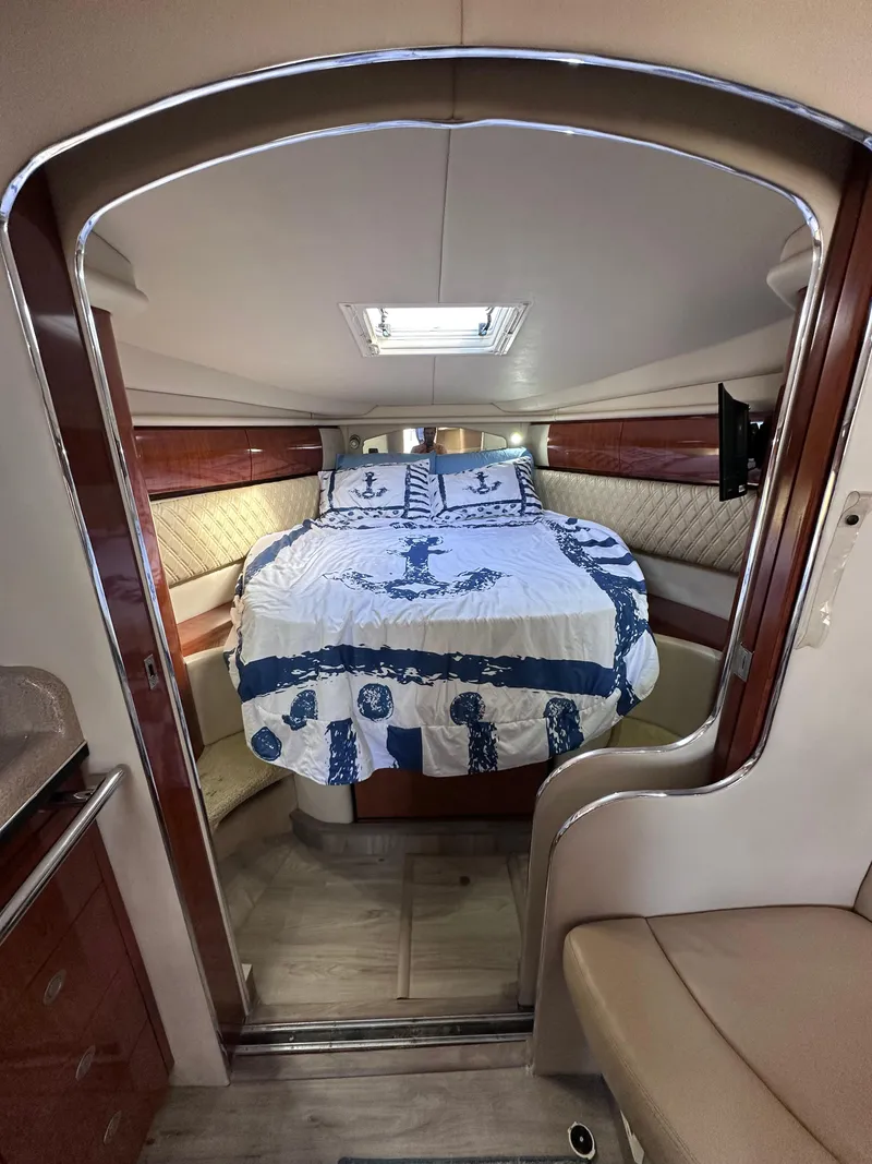 Slide: The Image of Luxurious 2004 Sea Ray 360 Sundancer cabin with nautical-themed bedding. - 21