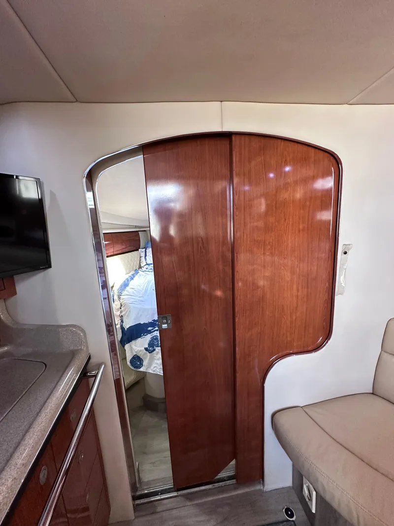 Slide: The Image of Interior of 2004 Sea Ray 360 Sundancer with wooden door and cozy seating area. - 22