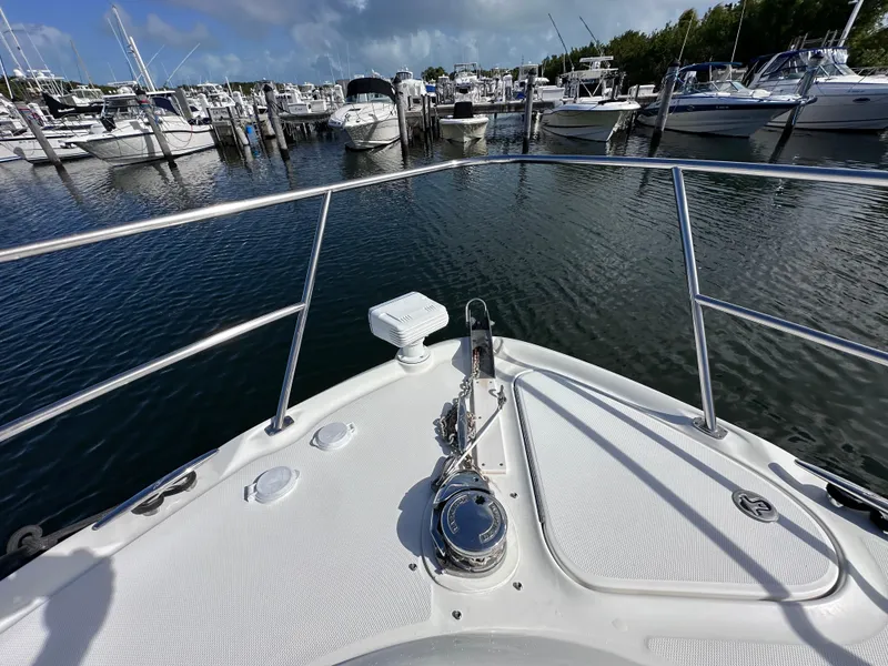 Slide: The Image of Bow view of 2004 Sea Ray 360 Sundancer in a marina, surrounded by boats. - 6