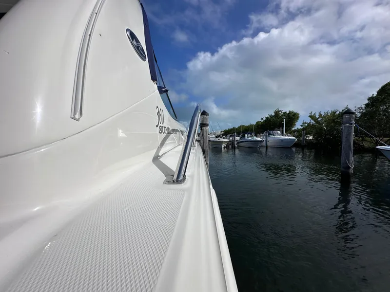 Slide: The Image of 2004 Sea Ray 360 Sundancer docked, side view with clear sky and water. - 9