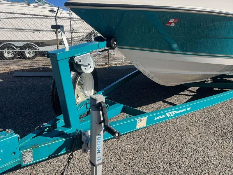 Slide: The Image of 1995 Regal Valanti 222 boat on a teal trailer in a parking lot. - 10