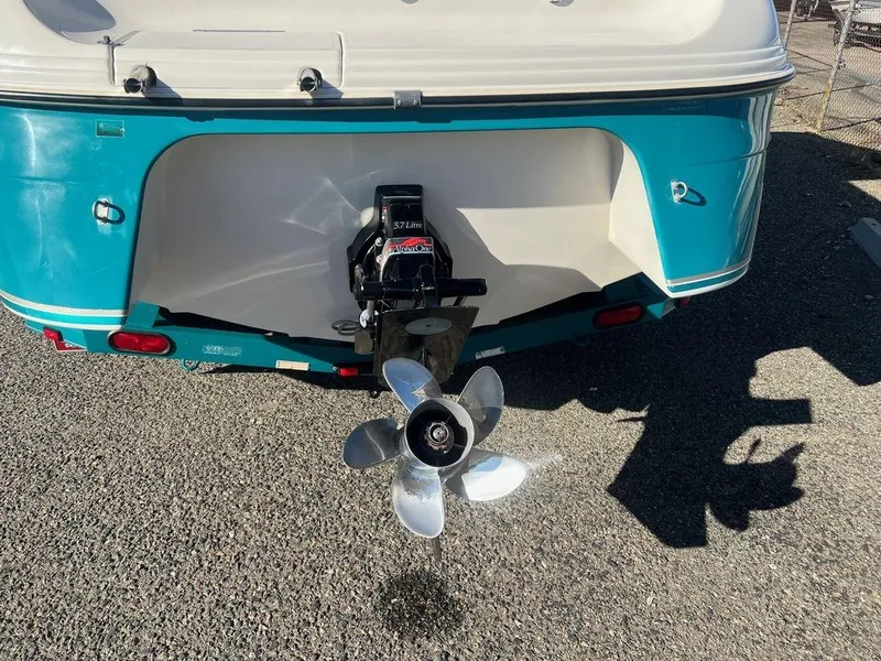 Slide: The Image of 1995 Regal Valanti 222 boat stern with propeller, teal and white color scheme. - 13