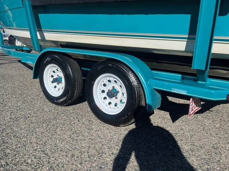 Slide: The Image of 1995 Regal Valanti 222 boat trailer with dual wheels on a sunny day. - 14