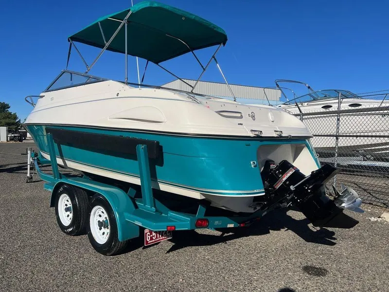 Slide: The Image of 1995 Regal Valanti 222 boat on trailer, teal and white, parked outdoors. - 15