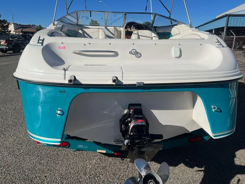 Slide: The Image of 1995 Regal Valanti 222 boat, rear view, teal and white, parked outdoors. - 18