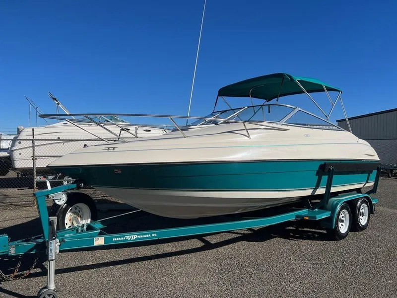 Slide: The Image of 1995 Regal Valanti 222 boat on trailer, teal and white, parked outdoors. - 2