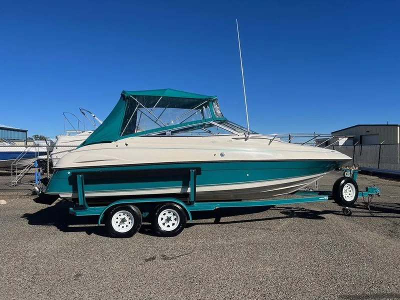 Slide: The Image of 1995 Regal Valanti 222 boat on trailer, teal and white, parked outdoors. - 47