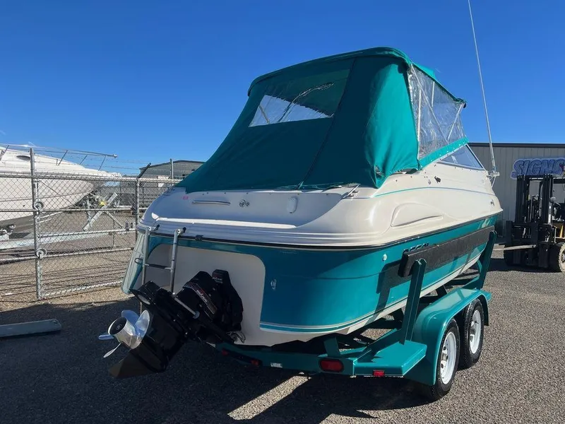 Slide: The Image of 1995 Regal Valanti 222 boat with teal cover on trailer in sunny marina. - 49